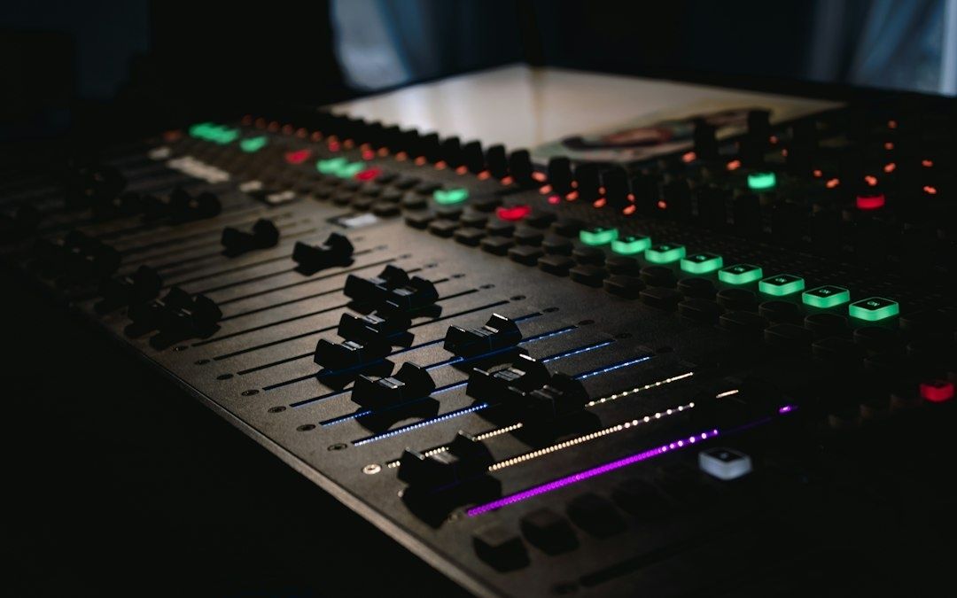 Close-up of a digital audio mixer with illuminated controls