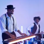 Musicians perform under blue and violet LED stage lighting