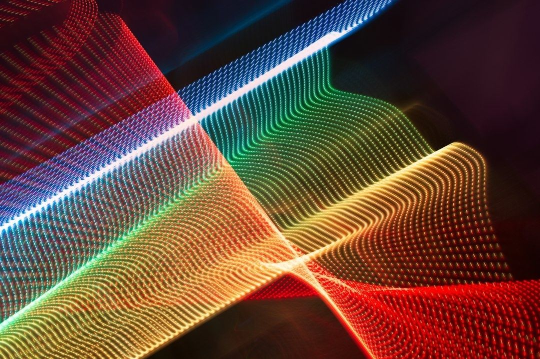 Abstract waves of red, green, blue, and gold LED light